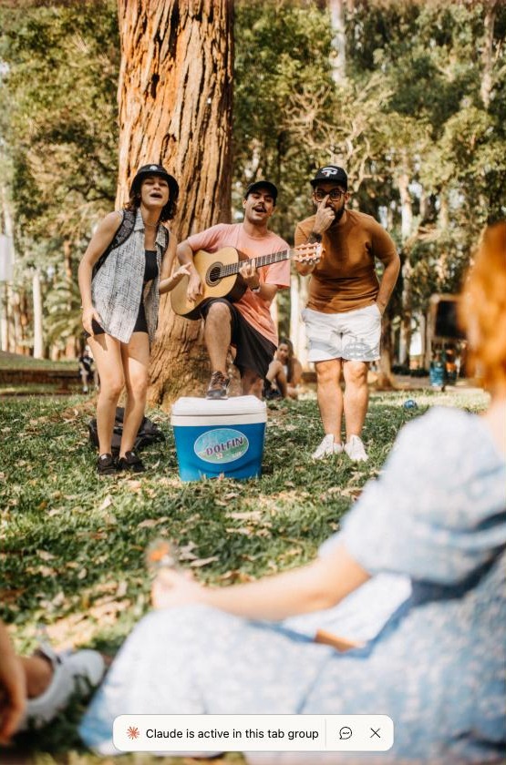 Amigos a cantar ao ar livre com uma guitarra, num parque